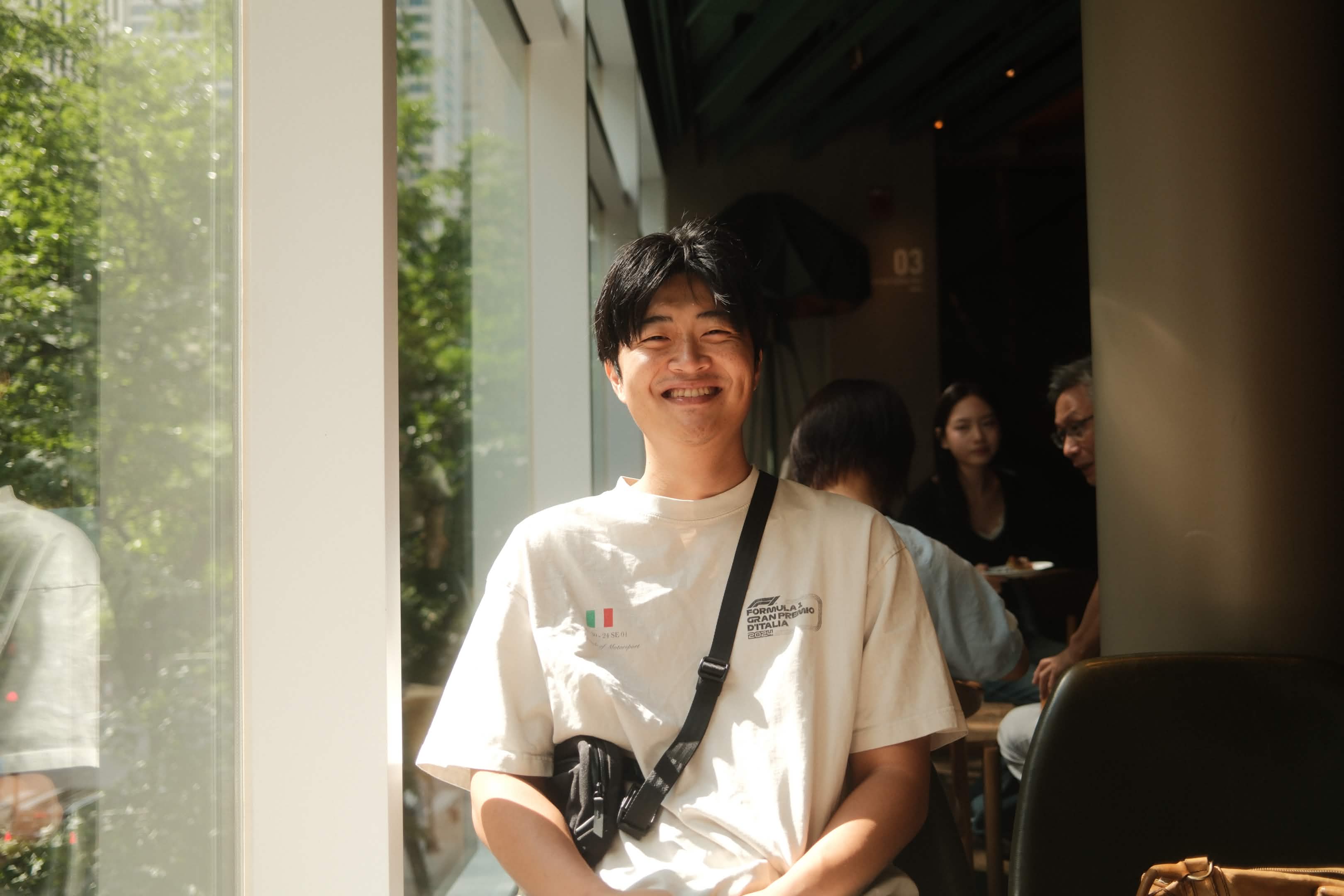 Andy smiling in a sunlit café